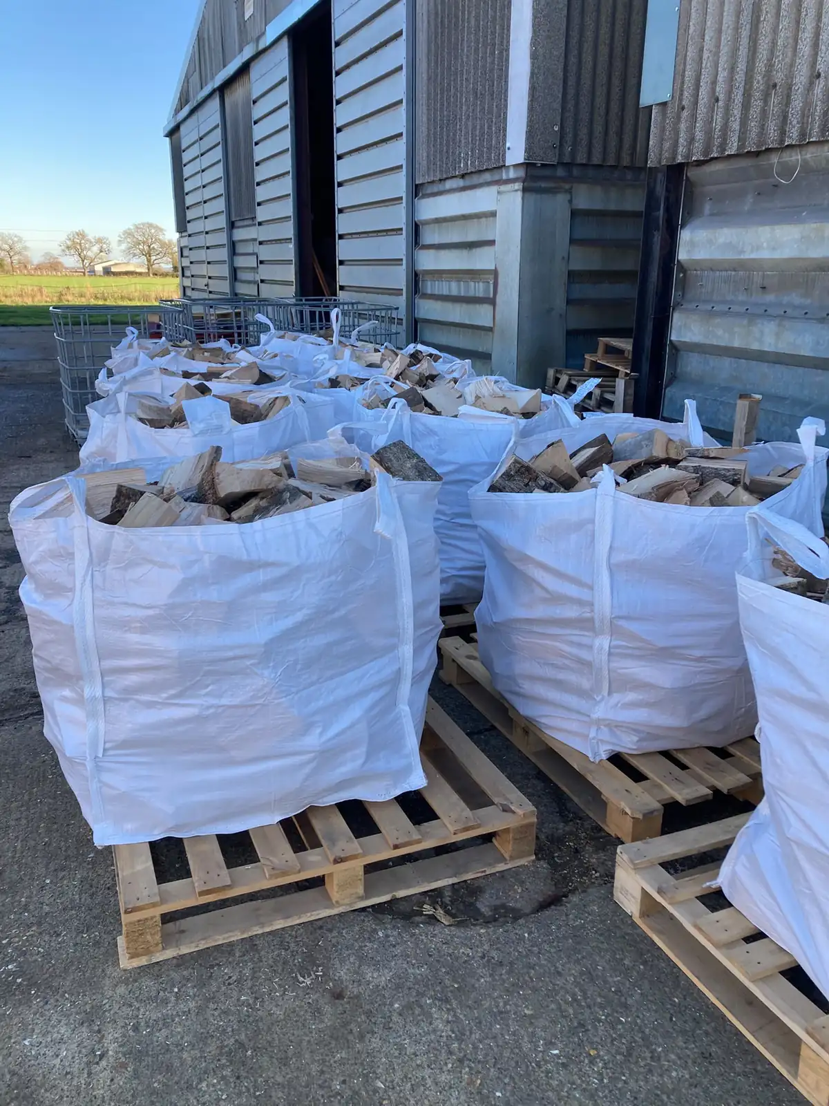 Bulk bags of seasoned logs on pallets in the AM Fuels yard